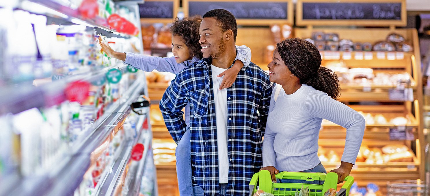 Happy millennials family shopping in retail grocery store young child