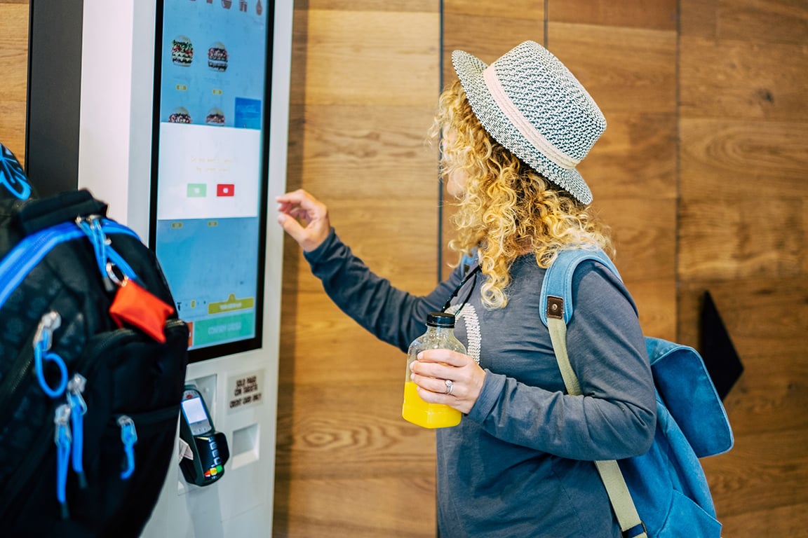 Woman using self service touch kiosk