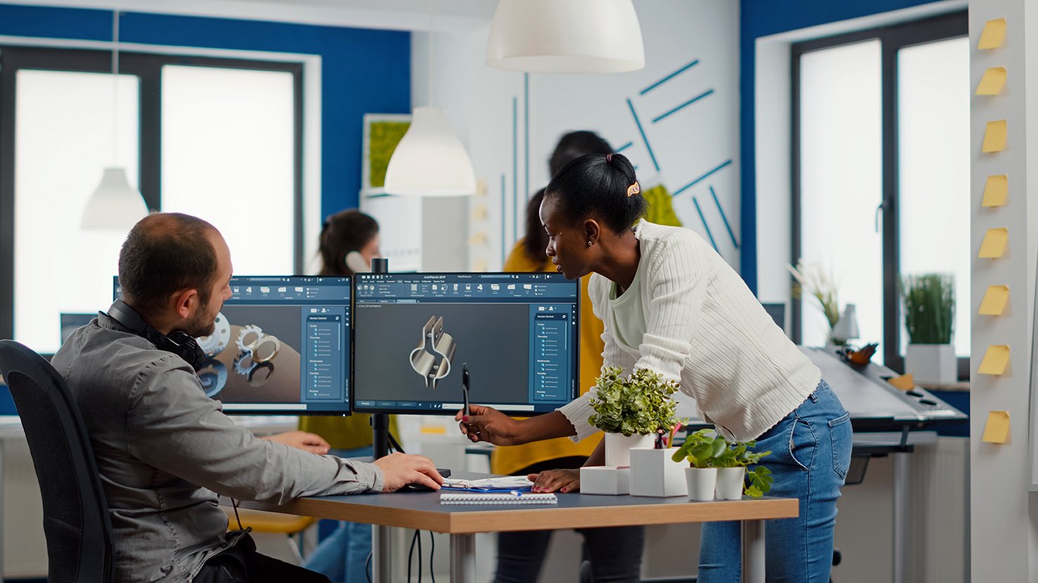 Diverse team of engineers working on computer at mechanical piece design cad sharing ideas