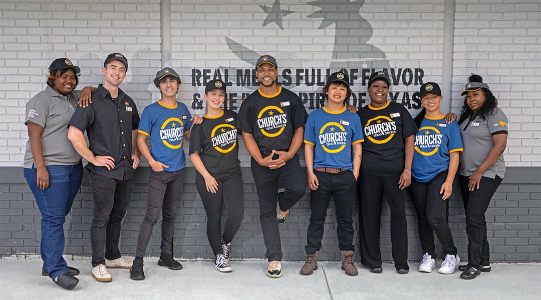 welcome crew for a fast food restaurant in front of a branded mural