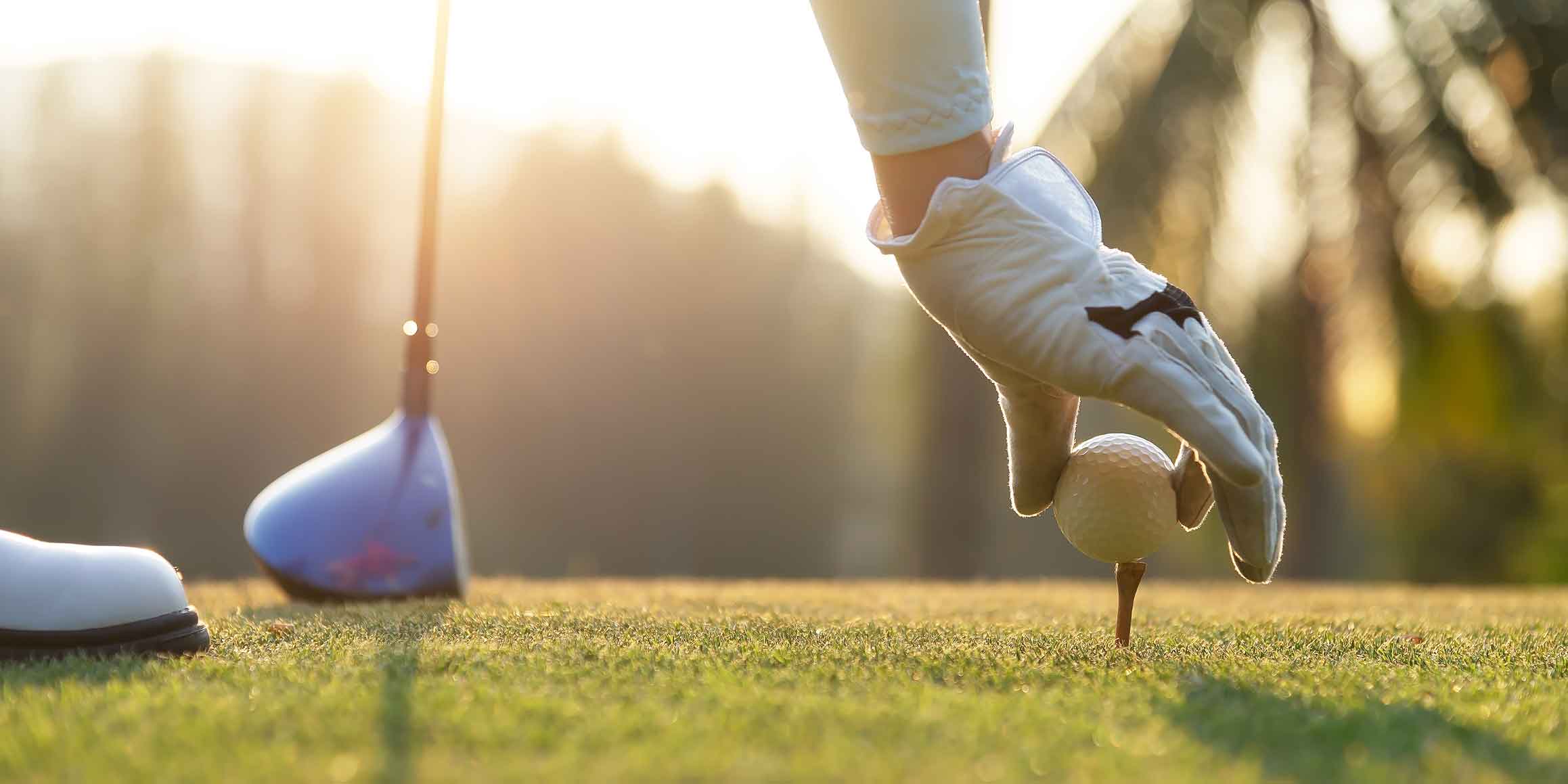 Golfer wearing white glove with golfing club in hand