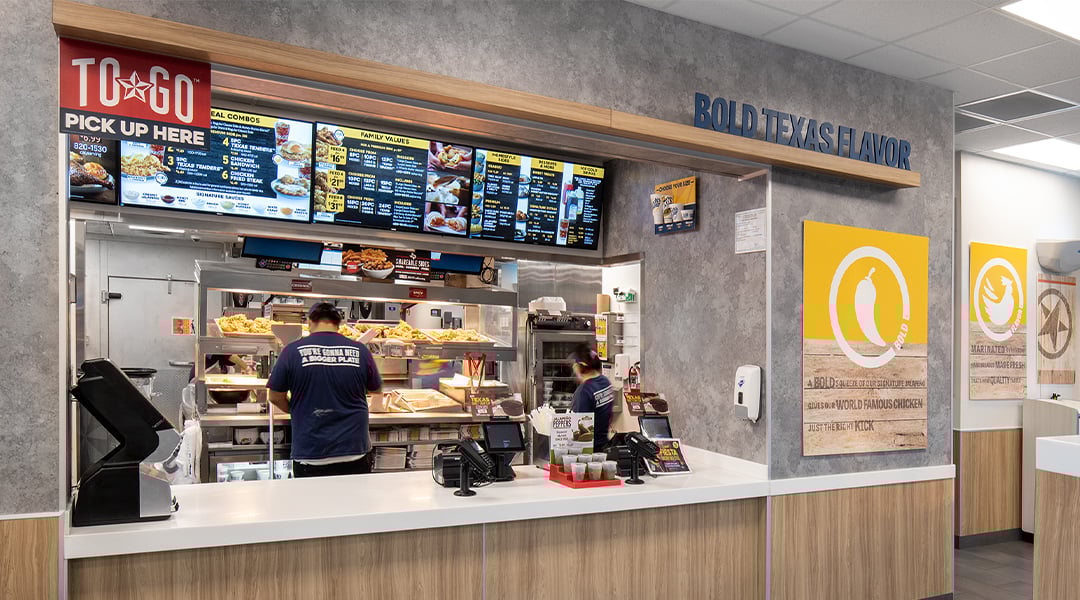 chicken restaurant cashwrap and digital displays with a grey wall and signage chicken restaurant cashwrap and digital displays with a grey wall and signage